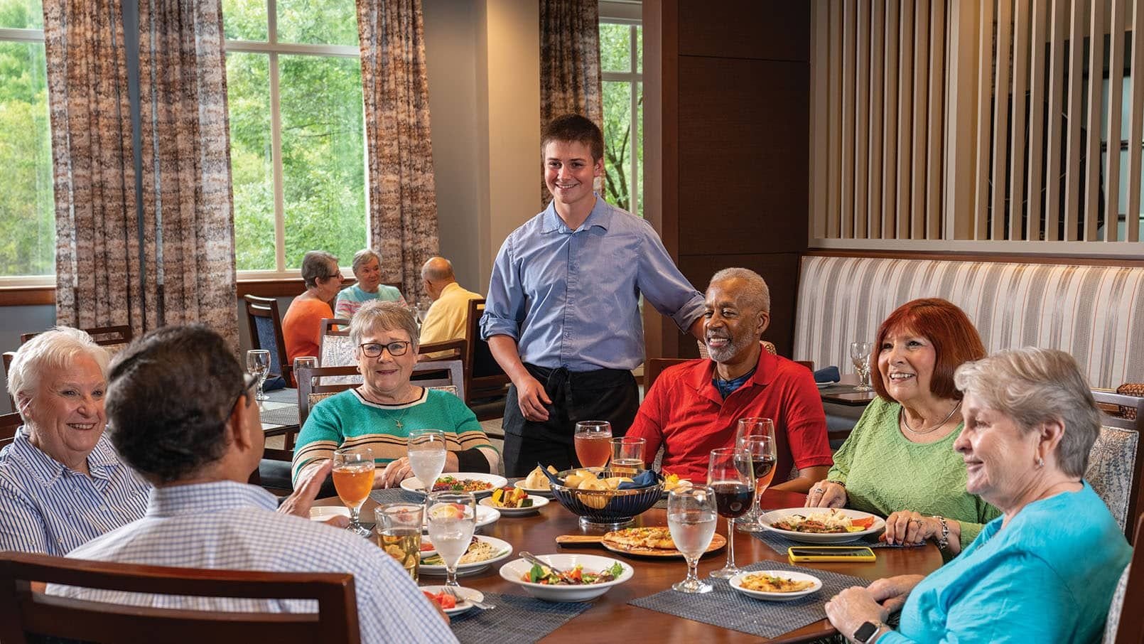 Maris Grove residents having a conversation with a server in the dining area